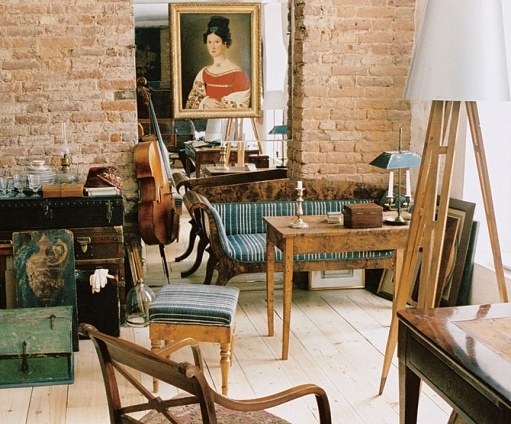 At the other end of the room, Dmitriev arranged a seating area made up of varied 18th-century furnishings and paintings. Exposed-brick walls and raw-toned wood floors add a sense of history to the room. For more light, the designer extended the lengths of the windows.